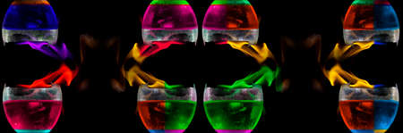 Colored liquid mixed with lighter fluid in a flaming cup where ice cubes are being placed to cause a...