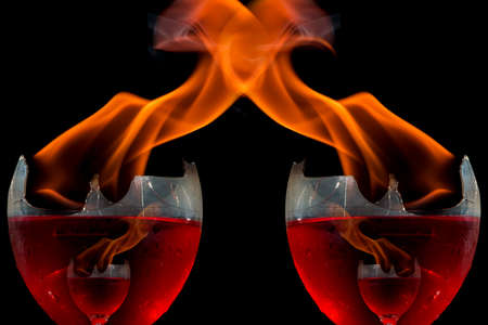 Colored liquid mixed with lighter fluid in a flaming cup where ice cubes are being placed to cause a...