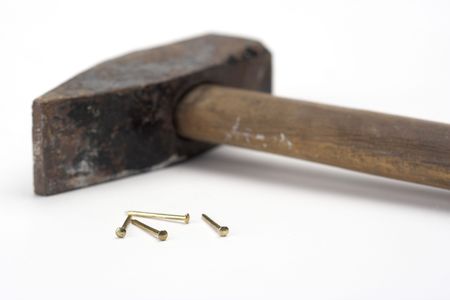 Hammer and golden nails isolated on white