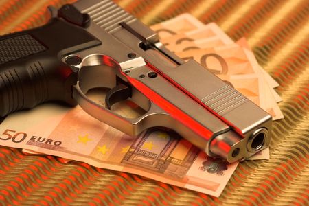 pistol over euro bills closeupの写真素材