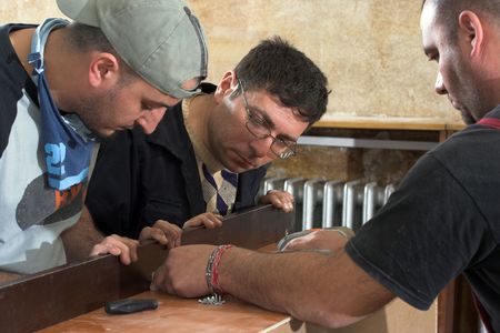 Three workers assembled wooden construction

