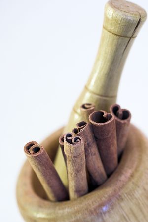 close up of cinnamon sticks in the mortarの写真素材