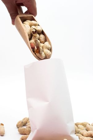 peanuts into paper bag over white