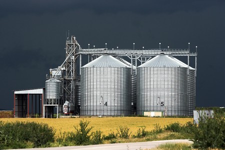View of grain silos against stormy skyの写真素材