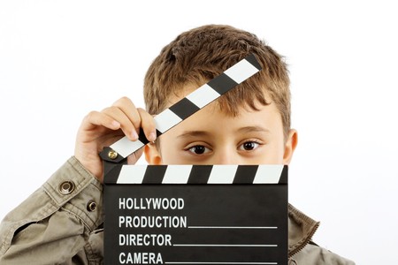 Boy with movie clapper board over whiteの写真素材