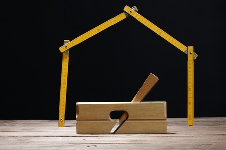 Carpenter's plane and yard-measure over blackの写真素材