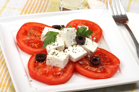 Tomato salad with feta cheese and sliced olivesの写真素材