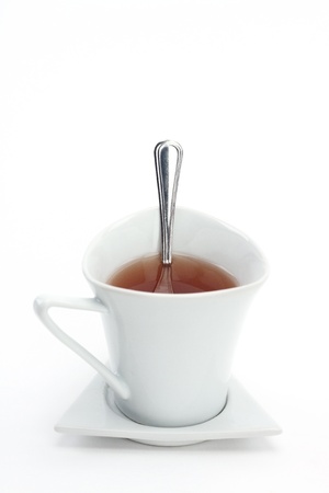Cup of tea and spoon over white, focus on the spoonの写真素材