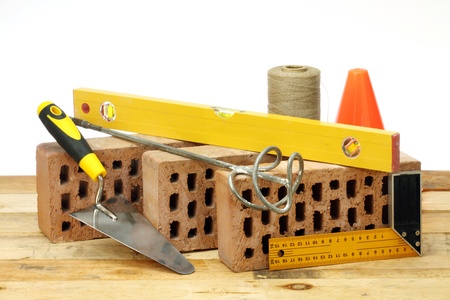 Bricks, trowel and stirrer on work place 