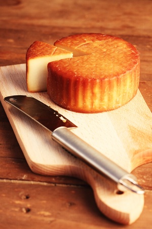 scissored cheese and knife on a wooden boardの写真素材