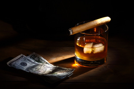 hat, glass of bourbon whiskey and cigarの写真素材