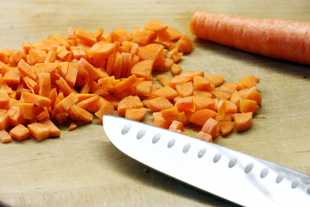 carrots cut  and kitchen knife on wooden plankの写真素材