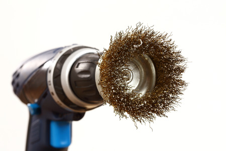 drill fitted with a wire brush on whiteの写真素材