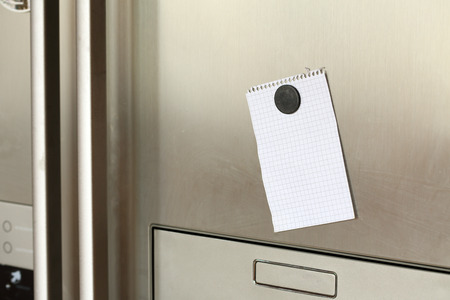 Blank paper and magnet on refrigerator door. の写真素材