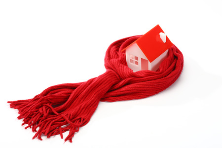Model of house wrapped in red scarf over whiteの写真素材