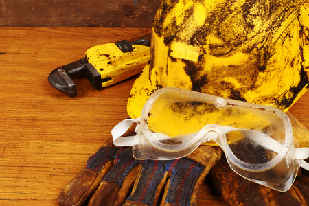 Dirty yellow helmet and tools on work placeの写真素材