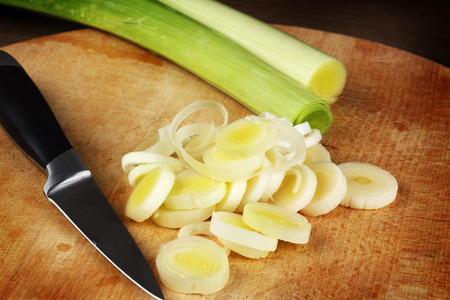 leeks chopped on wooden table, close upの写真素材
