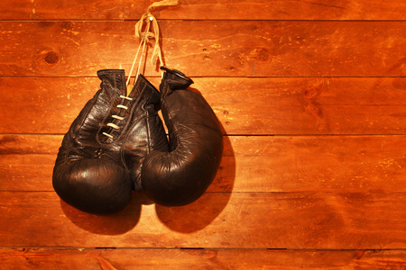 old boxing gloves hang on wooden wallの写真素材