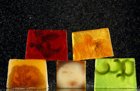 color handmade backlit soap and water drops over blackの写真素材