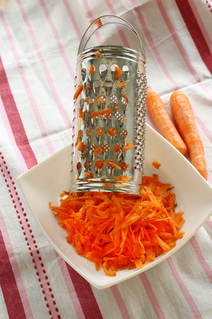 pile of grated carrots in white plateの写真素材