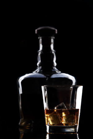 silhouette of a bottle of whiskey and glass on blackの写真素材
