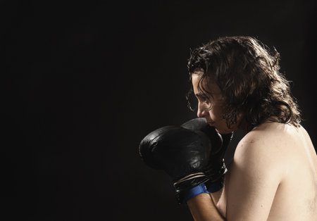a young man is boxing over black