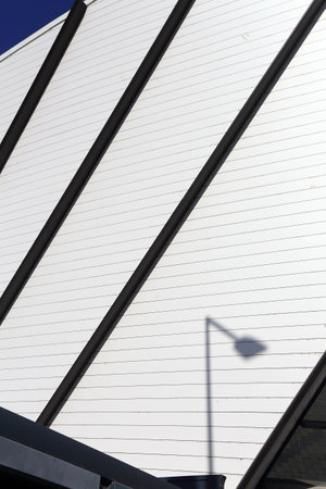 part of the facade of a modern city building against a blue sky backgroundの写真素材