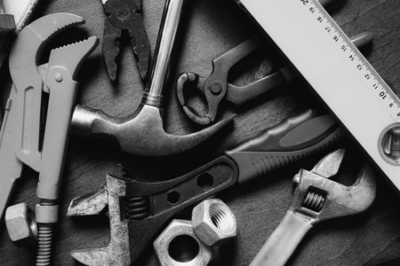 banch of different hand tools over workplace black and whiteの写真素材
