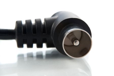 Close up and low level angle of a black RF aerial lead arranged over white.の写真素材