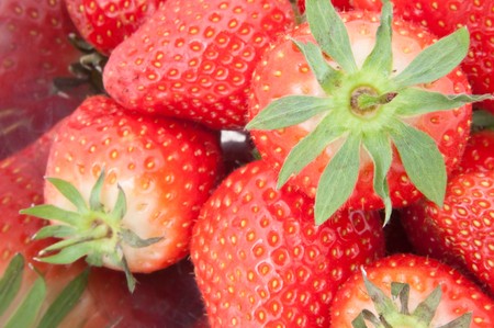 Close up of many fresh strawberries in a stainless steel bowl.の写真素材