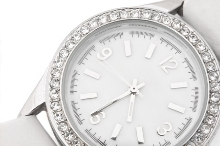 Close up capturing a white and chrome watch face with diamond surround over white.の写真素材