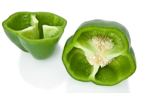 Close up capturing two halves of a green bell pepper arranged over white.の写真素材