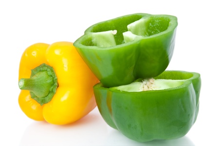 Close up capturing a small selection of whole and halved bell peppers arranged over white.の写真素材