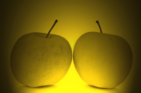 Two fresh apples surrounded by golden light effect filterの写真素材