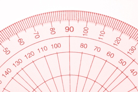 Close Up capturing a portion of a transparent plastic protractor arranged over white.