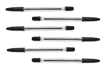 Six black biro pens arranged horizontally in formation over whiteの写真素材