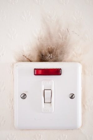 Photograph capturing the damage caused to an electrical point by faulty wiring 
