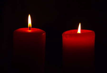 two burning candles against a dark backgroundの写真素材