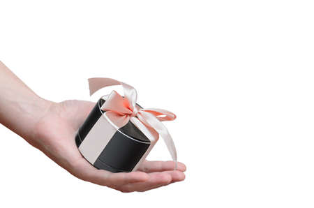portable mobile speaker, tied with a pink ribbon in man's hand isolated on white backgroundの写真素材