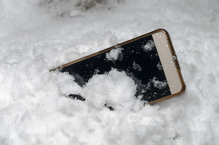 Mobile phone fell in the snowの写真素材