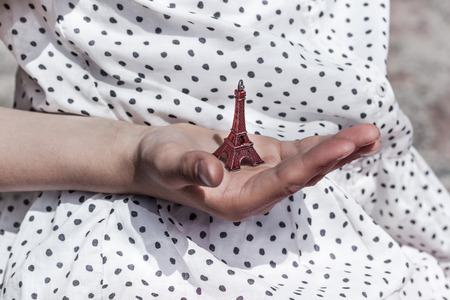 Red Eiffel Tower miniature in a retro girls hand