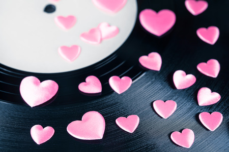 Detail of vintage record with white blank label and many pink decorative heartsの写真素材
