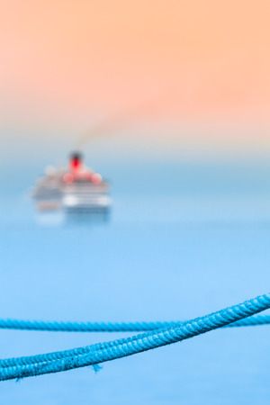 Blue rope harbor detail, departed cruise ship at blurred background (copy space)の写真素材
