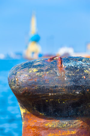 Huge harbor mooring bollard with number 1 on it at port, sea and crane background (copy space)の写真素材