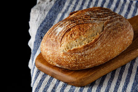 Traditional wheat freshly rustic baked bread on napkin. Artisan sourdough bread.