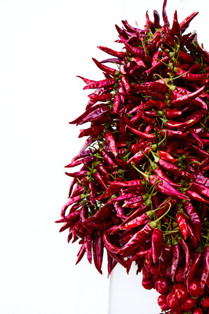 Red Spicy Hot Chili Peppers Drying On A White Wallの写真素材