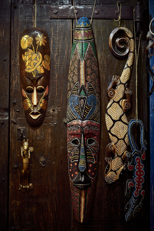 wooden voodoo mask and  lizard on the background of a wooden door on metal hingesの写真素材