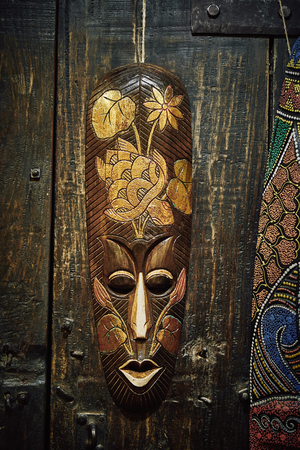 wooden voodoo mask and  lizard on the background of a wooden door on metal hingesの写真素材