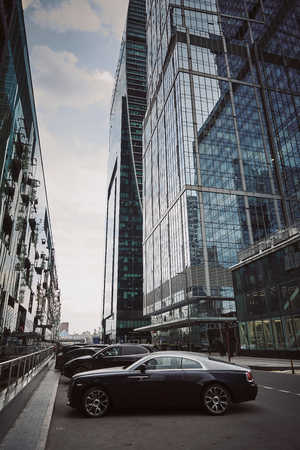 Moscow City skyscrapers in summer in cloudy weather and a luxury car near itの写真素材