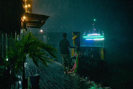 Thai national boat moored to the pier and the guy holds her, meeting guestsの写真素材